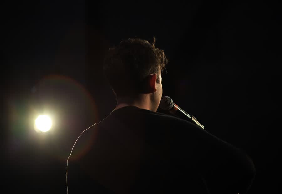 Cantante di spalle illuminato da un fascio di luce